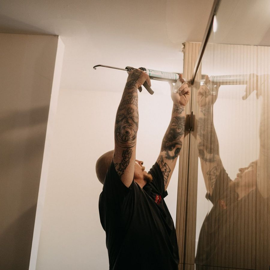 Budget Glass installer sealing a new shower glass enclosure